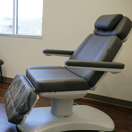 Examination room featuring a patient exam table and a patient chair for patient accompanied guests